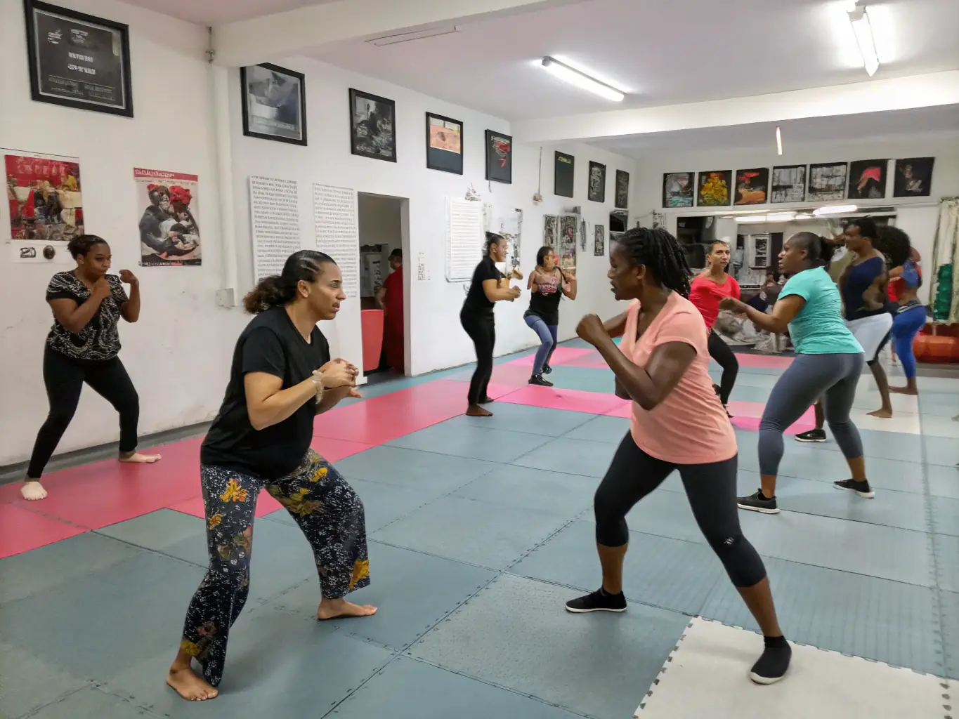 A group of adults participating in a self-defense training session, focusing on practical techniques and safety measures, set in a community center.